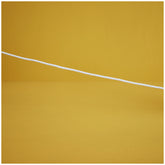 A white cotton cord stretches across a vibrant yellow background, suggesting playfulness and connection for children's toys.